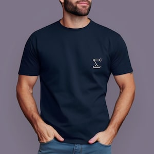 Puede incluir: Camiseta azul marino con un pequeño gráfico blanco de un brazo robótico en el pecho. La camiseta tiene mangas cortas y cuello redondo. El fondo es de color neutro.