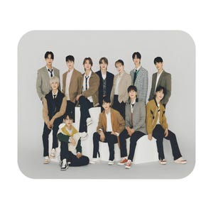 Könnte beinhalten: Eine Gruppe junger Erwachsener posiert zusammen in verschiedenen Outfits, darunter Blazer und Jacken. Die Gruppe sitzt und steht auf einer weißen Oberfläche, mit einem schlichten weißen Hintergrund. Die Kleidung ist in Braun, Schwarz und Grün gehalten.