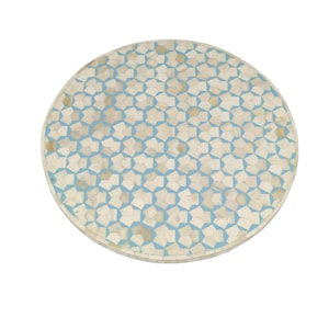 Puede incluir: Una mesa redonda con un patrón de mosaico. El mosaico presenta un diseño de estrella repetido en blanco roto y azul claro. La mesa es una pieza decorativa, adecuada para varios estilos de diseño de interiores.