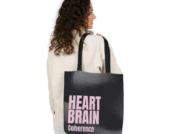 May include: A black tote bag with two black shoulder straps. The front of the bag features the text "HEART BRAIN" in large, light pink capital letters, with the word "Coherence" printed in smaller light pink letters directly underneath.