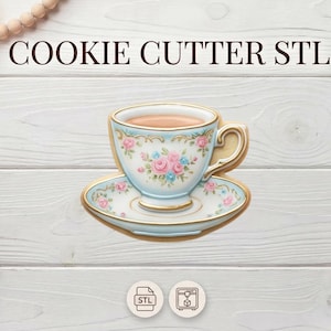 Pode incluir: Um cortador de biscoitos em forma de chávena e pires, decorado com padrões florais rosa e azul e acabamentos dourados. As palavras "COOKIE CUTTER STL" estão na parte superior.