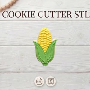 May include: A corn-shaped cookie cutter with a yellow corn cob and green leaves. The text "COOKIE CUTTER STL" is displayed above the cookie cutter. The image is on a white wooden background.
