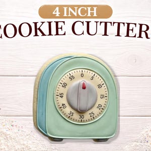 May include: A 4-inch cookie cutter shaped like a vintage kitchen timer. The cutter is light green, blue, and cream-colored, with a timer face showing numbers. The words "4 INCH COOKIE CUTTERS" are above the cutter.