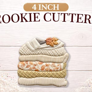 May include: A stack of 4-inch cookie cutters shaped like a sweater, with various textured and patterned layers. The top layer has a collar and a leaf. The text "4 INCH COOKIE CUTTERS" is above the cutters.