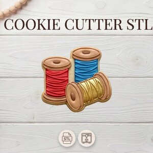Può includere: Tre formine per biscotti a forma di rocchetti di filo rosso, blu e oro. Le formine sono su una superficie di legno bianco. Il testo "COOKIE CUTTER STL" è nella parte superiore dell'immagine.