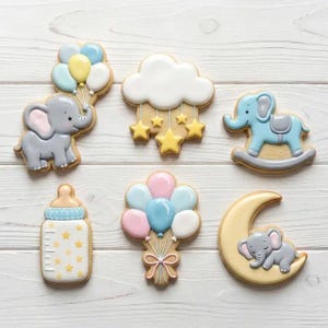 May include: A set of six decorated sugar cookies featuring a gray elephant with balloons, a white cloud with yellow stars, a blue rocking elephant, a baby bottle with yellow stars, a cluster of pink and blue balloons, and a gray elephant on a moon.