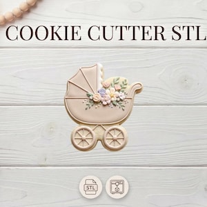 May include: A beige cookie cutter in the shape of a baby carriage, decorated with pastel-colored flowers. The text "COOKIE CUTTER STL" is displayed above the carriage. The image is set against a white wooden background.