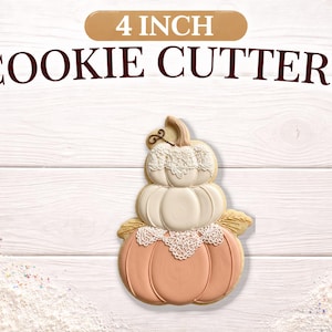 May include: A stacked pumpkin cookie cutter, 4 inches in size, with a detailed design. The cookie cutter is made of a light orange, white, and beige color. The text "4 INCH COOKIE CUTTERS" is displayed above the cookie cutter.