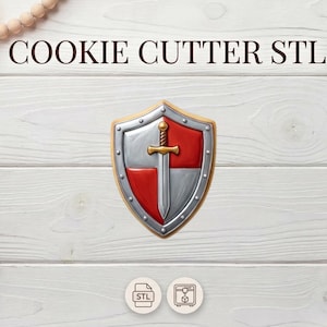 May include: A cookie cutter in the shape of a shield with a sword. The shield is silver and red with a gold border. The text "COOKIE CUTTER STL" is at the top of the image. The background is a white wooden surface.
