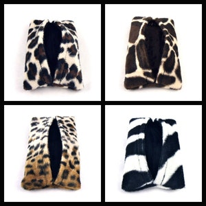 May include: Four tissue box covers with different animal print designs. The covers are made of soft, plush fabric and feature a black interior. The designs include leopard print, giraffe print, zebra print, and cheetah print.