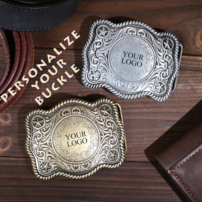 May include: Two decorative metal belt buckles, one silver and one bronze, with space for a logo. The buckles have a star and scroll design. The image includes the text "PERSONALIZE YOUR BUCKLE".