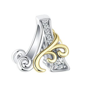 May include: A silver and gold charm in the shape of the letter "A". The silver section has a row of small, clear gemstones, while the gold part has a decorative, swirling design. A single, larger gemstone is set in the gold.