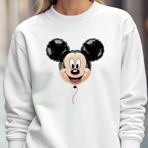 May include: White sweatshirt featuring a Mickey Mouse balloon design. The balloon has black ears, a smiling face, and a red string. The sweatshirt is a solid white color.