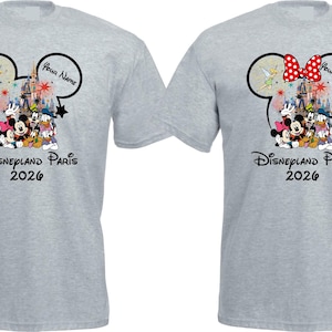 May include: Two light gray t-shirts featuring a Disney design. One shirt has a red polka dot bow on the Mickey Mouse ears, the other does not. Both shirts display Disney characters, the text "Disneyland Paris 2026", and a space for a name.
