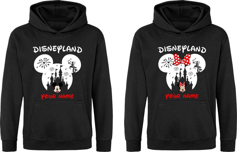 以下が含まれることがあります： 黒いパーカー。デザインは、花火、お城、赤い「Your Name」の文字と「Disneyland」の文字が上に書かれた白いミッキーマウスの頭が特徴です。1つは赤いリボンが付いています。
