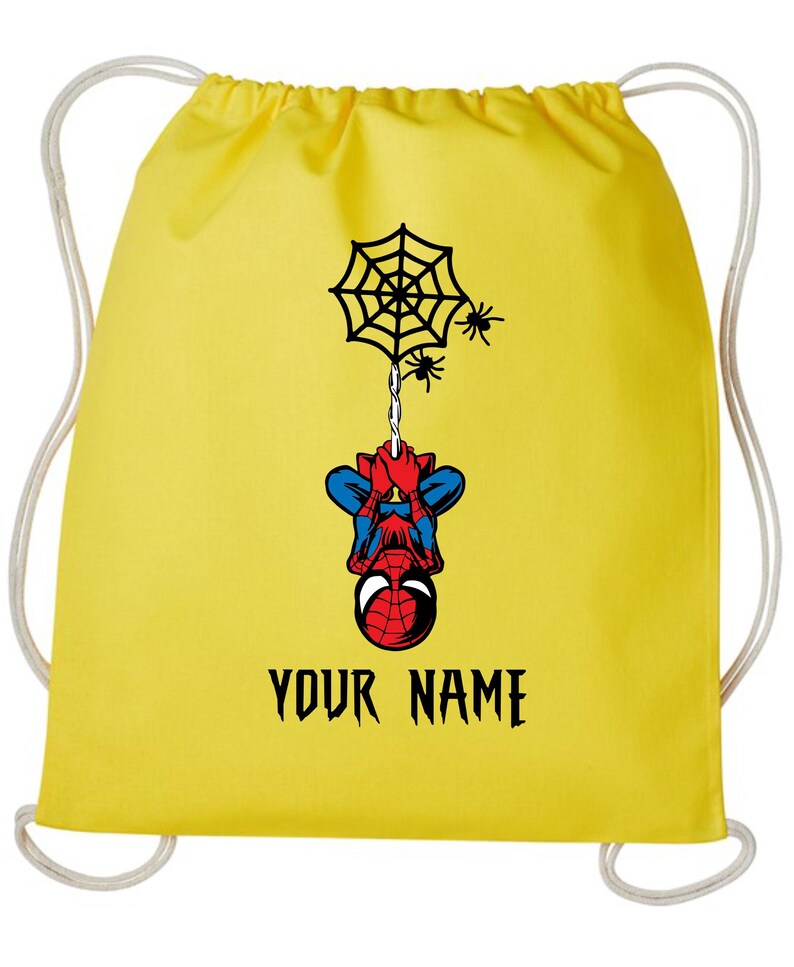 Puede incluir: Mochila con cord&oacute;n amarilla con un dise&ntilde;o de Spider-Man. El dise&ntilde;o incluye una telara&ntilde;a, ara&ntilde;as y el texto "YOUR NAME" en negro. La mochila tiene cordones blancos.