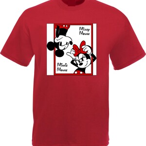 May include: Red t-shirt featuring a graphic of Mickey and Minnie Mouse. The design includes the text "Mickey Mouse" and "Minnie Mouse" in black font. Mickey is upside down, and Minnie is smiling with a red bow.