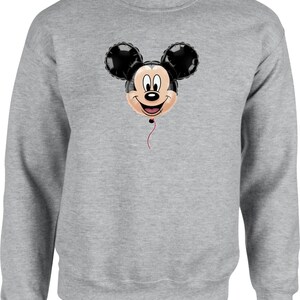 May include: A gray sweatshirt featuring a Mickey Mouse balloon design. The balloon has black ears, a smiling face, and a red string. The sweatshirt is a solid gray color.