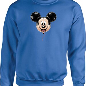 May include: A blue sweatshirt featuring a Mickey Mouse balloon graphic. The balloon has black ears and a smiling face, with a red string. The sweatshirt is a solid blue color.