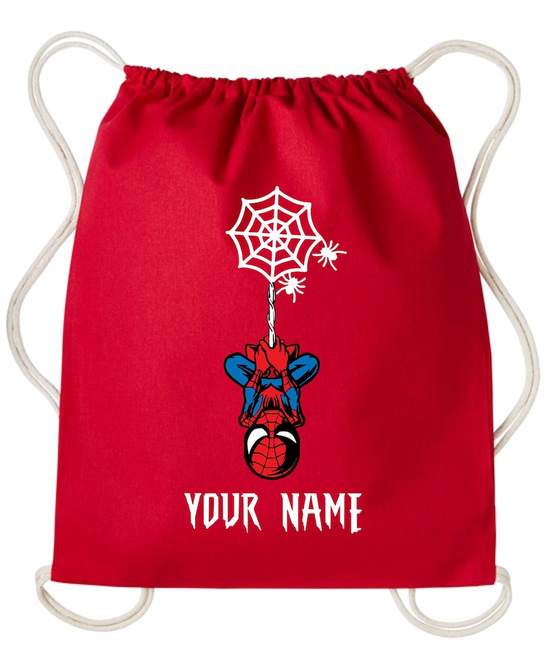 Puede incluir: Mochila roja con cord&oacute;n con un dise&ntilde;o de Spider-Man. Presenta una telara&ntilde;a blanca, ara&ntilde;as y una ilustraci&oacute;n de Spider-Man boca abajo. El texto "YOUR NAME" est&aacute; impreso en blanco en la parte inferior. Cordones blancos.