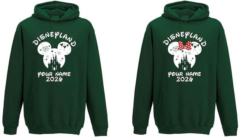 May include: Two dark green hoodies with white text and graphics. The hoodies feature a Mickey Mouse head design with a castle silhouette and the text "Disneyland", "Your Name", and "2026". One hoodie has a red bow.