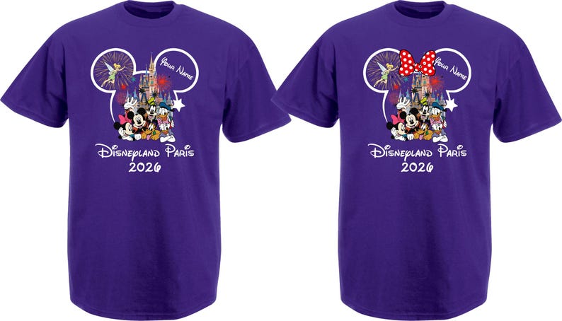 May include: Two purple t-shirts with a Disney theme. Each shirt features a Mickey Mouse head outline with a castle, fireworks, and Disney characters. The text "Disneyland Paris 2026" is printed below the graphic. One shirt has a red bow.