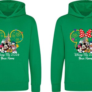 May include: Two bright green hooded sweatshirts featuring a graphic of Mickey Mouse, Minnie Mouse, Donald Duck, and Goofy in front of a castle with fireworks. The text reads Disney Trip 2026 and Your Name. One hoodie includes a red and white polka dot bow.