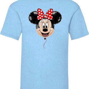 Pu&ograve; includere: T-shirt azzurra con un disegno a palloncino di Minnie Mouse. Il palloncino ha orecchie nere, un fiocco rosso a pois bianchi e una faccia sorridente. Un filo rosso pende dal fondo del palloncino.