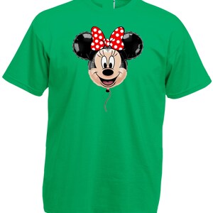 Pu&ograve; includere: Una maglietta verde con un disegno a palloncino di Minnie Mouse. Il palloncino ha orecchie nere, una faccia sorridente e un fiocco rosso a pois bianchi. Un filo rosso pende dal fondo del palloncino.