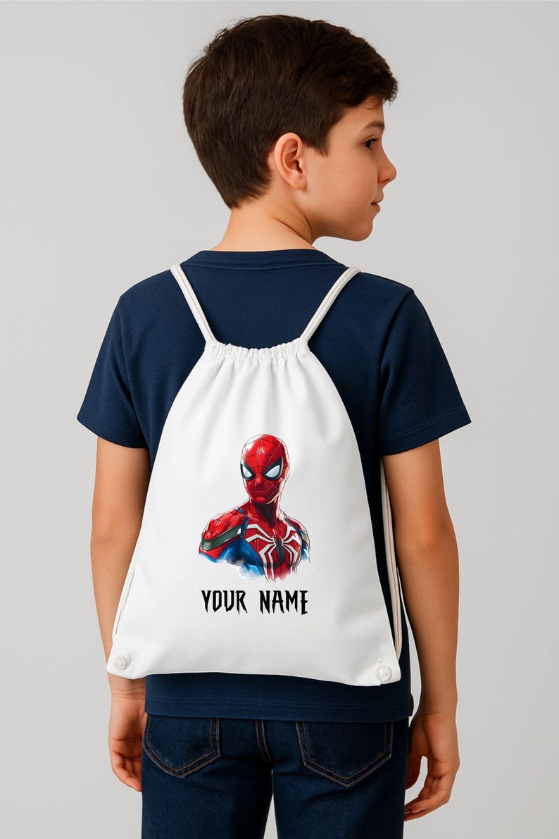 May include: White drawstring backpack featuring a vibrant illustration of Spider-Man. The superhero is depicted in his classic red and blue suit. The text "YOUR NAME" is printed in black below the image. The backpack has white drawstrings.