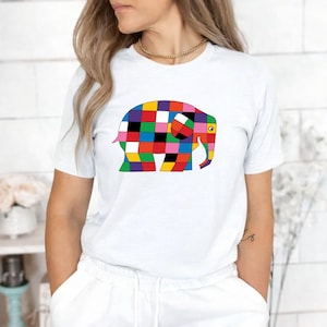Könnte beinhalten: Weißes T-Shirt mit einem farbenfrohen Elefanten-Design im Patchwork-Stil. Der Elefant besteht aus Quadraten in verschiedenen Farben. Das T-Shirt hat kurze Ärmel und einen Rundhalsausschnitt. Das Design ist auffällig und verspielt.