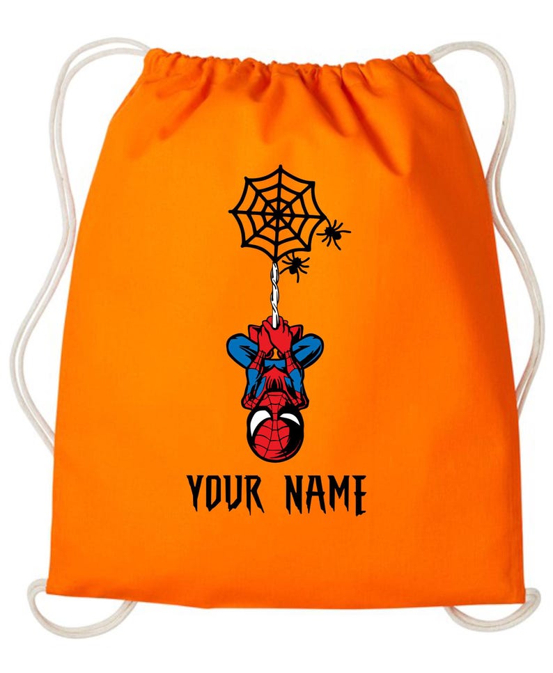 Puede incluir: Mochila con cord&oacute;n naranja con un dise&ntilde;o de Spider-Man. El superh&eacute;roe est&aacute; colgado de una telara&ntilde;a. El texto "YOUR NAME" est&aacute; impreso en negro debajo. Cordones blancos.
