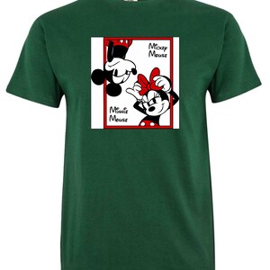 May include: A dark green t-shirt featuring a graphic of Mickey and Minnie Mouse. The graphic is in a red-bordered white square, with Mickey upside down and Minnie right-side up. The words "Mickey Mouse" and "Minnie Mouse" are also in the graphic.