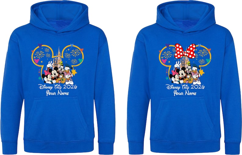 May include: Two royal blue hooded sweatshirts featuring a graphic of Mickey Mouse, Minnie Mouse, Donald Duck, and Goofy in front of a castle with fireworks. The text reads Disney Trip 2026 and Your Name. One hoodie includes a red and white polka dot bow.