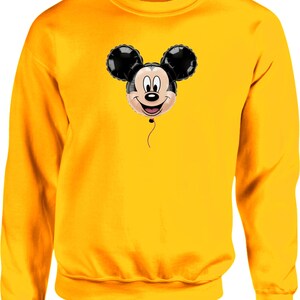 May include: A yellow sweatshirt featuring a smiling Mickey Mouse balloon graphic. The balloon has black ears and a smiling face. The sweatshirt is a solid yellow color.