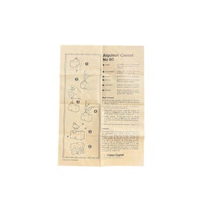 May include: A vintage instruction sheet for an Aiguisoir Castell No 60 pencil sharpener. The sheet is beige with black text and illustrations detailing the sharpener's use. The Faber-Castell logo is visible.