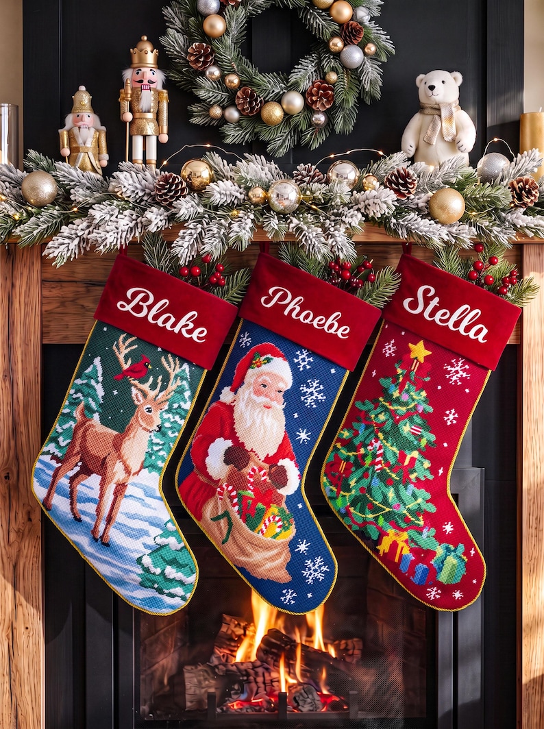 May include: Three personalized Christmas stockings with red velvet cuffs featuring the names Blake, Phoebe, and Stella. The stockings display needlepoint designs of a deer in a snowy forest, Santa Claus with a gift sack, and a decorated tree.