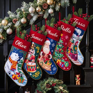May include: Five personalized Christmas stockings featuring embroidered names Olive, James, Phoebe, Stella, and Tessa. The stockings display festive needlepoint designs including a polar bear, nutcracker, Santa Claus, Christmas tree, and a steam train.