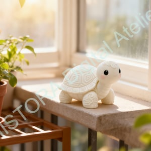 May include: A white ceramic turtle ornament with a detailed shell design and a smiling face. The turtle is on a stone ledge by a window, with plants in the background. The figurine is approximately 10 cm long.