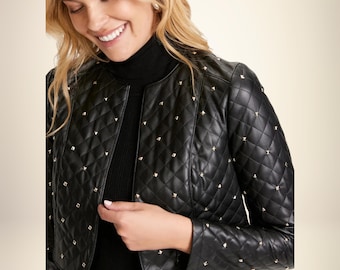 May include: Black quilted leather jacket with gold-colored stud accents. The jacket has a cropped design and a collarless neckline. The diamond-patterned stitching adds texture. The jacket is worn over a black turtleneck.