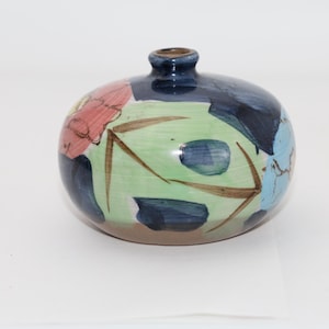 Könnte beinhalten: Eine runde Keramikvase mit dunkelblauem Hals und bauchigem Körper. Die Vase ist mit abstrakten floralen Designs in Rot-, Blau-, Grün- und Brauntönen verziert. Die Vase hat einen Durchmesser von etwa 15 cm.