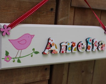 Personalised handmade wooden door sign with multicoloured floral lettering and bird illustration