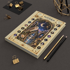 May include: A hardcover book titled Atlas of Intuition The Quiet Knows with a cream-colored cover featuring a detailed illustration of an owl, a crescent moon, stars, and stone arches. The book is accompanied by a gold pencil and a black pencil.
