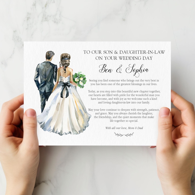 Puede incluir: Una tarjeta de boda rectangular con una ilustraci&oacute;n en acuarela de una pareja con ropa formal. El texto dice: TO OUR SON & DAUGHTER-IN-LAW ON YOUR WEDDING DAY, Ben & Sophia, seguido de un mensaje y firmado con With all our love, Mom & Dad.