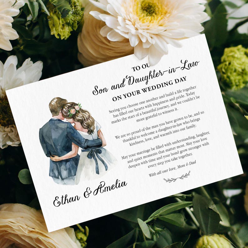 Puede incluir: Una tarjeta de boda blanca con una ilustraci&oacute;n en acuarela de una pareja abrazada, con texto impreso en negro: TO OUR Son and Daughter-in-Law ON YOUR WEDDING DAY, seguido de un mensaje y los nombres Ethan & Amelia.