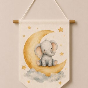 May include: A cream-colored fabric wall banner featuring a watercolor illustration of a gray elephant sitting on a yellow crescent moon surrounded by gray clouds and yellow stars. The banner hangs from a wooden rod with a white cord and displays Code: 12.