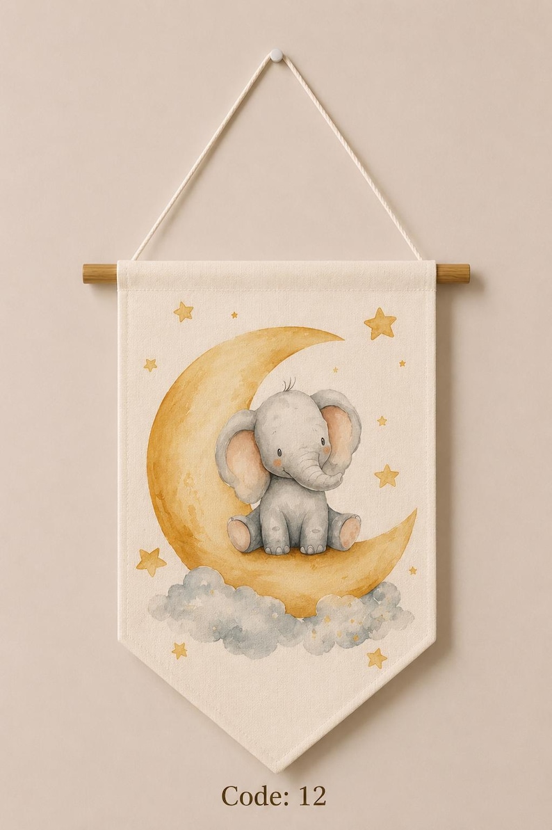 May include: A cream-colored fabric wall banner featuring a watercolor illustration of a gray elephant sitting on a yellow crescent moon surrounded by gray clouds and yellow stars. The banner hangs from a wooden rod with a white cord and displays Code: 12.