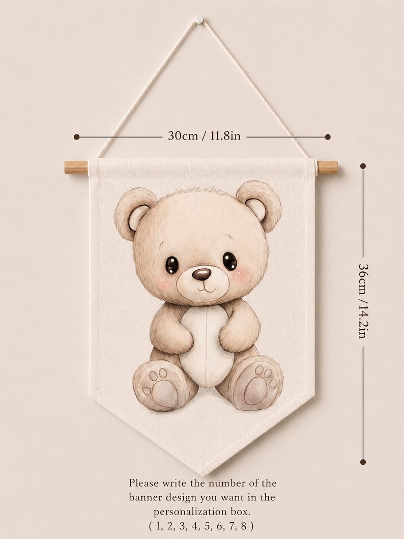 May include: A beige fabric wall banner featuring a brown teddy bear illustration. The banner measures 11.8 inches wide by 14.2 inches high and hangs from a wooden rod. Text at the bottom reads: Please write the number of the banner design you want in the personalization box. ( 1, 2, 3, 4, 5, 6, 7, 8 )
