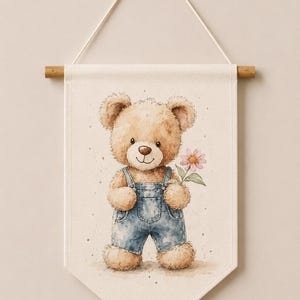 May include: A cream-colored fabric wall banner featuring a watercolor illustration of a light brown teddy bear wearing blue denim overalls and holding a single pink flower. The banner hangs from a wooden rod with a white string. The text Code: 7 is visible.