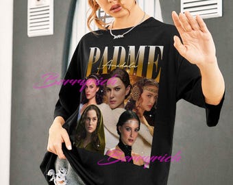 May include: Black oversized t-shirt featuring a graphic of Padmé Amidala from Star Wars. The design includes the word "Padmé" in gold lettering and multiple images of the character. The shirt is worn by a person.